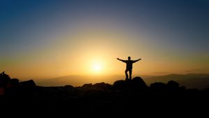 Image of a man feeling liberated after climbing a mountain. I had a similar feeling after conquering one recent experience through emotional release.